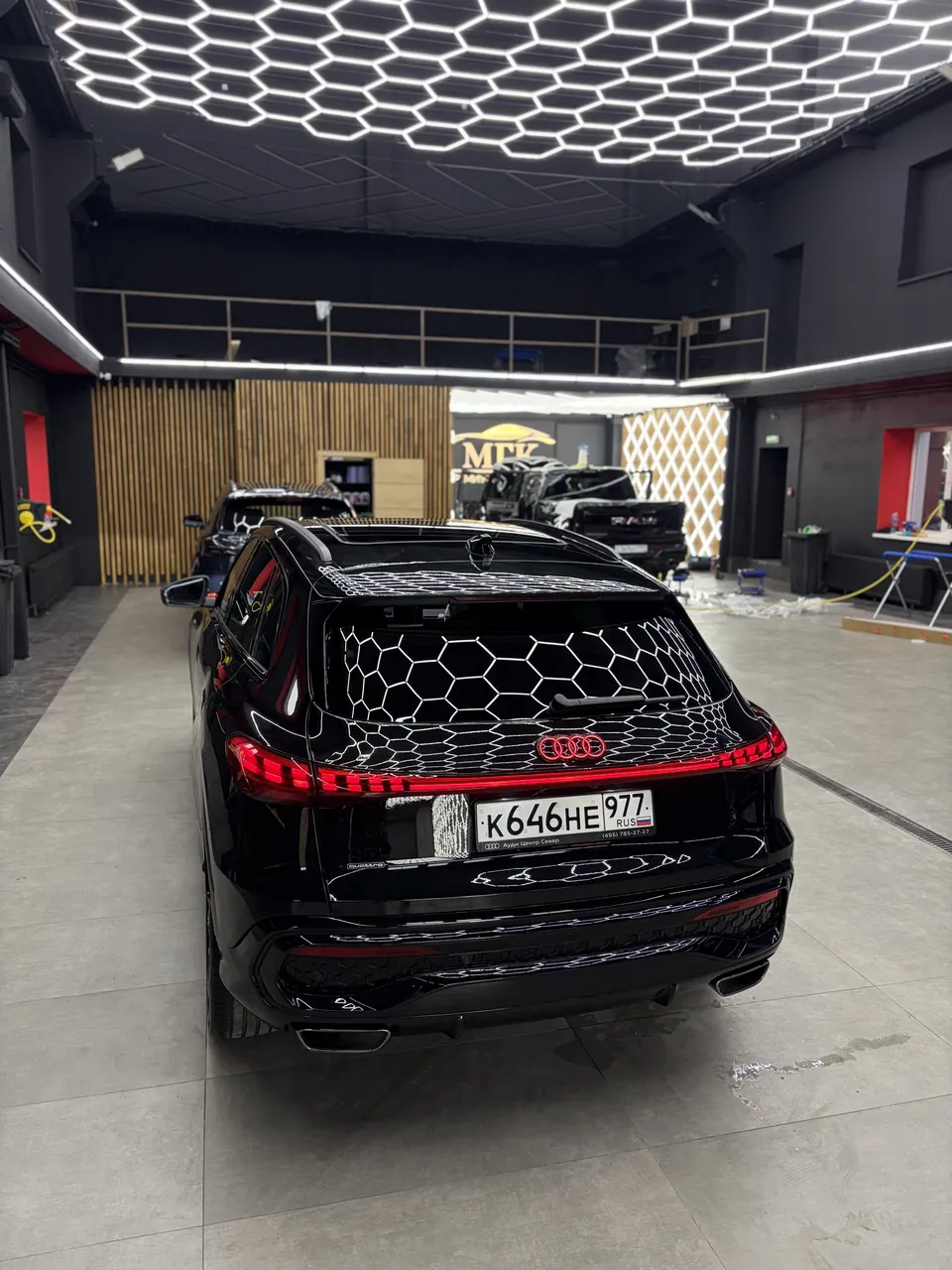 Чёрный кроссовер Audi после детейлинга под профессиональным освещением студии