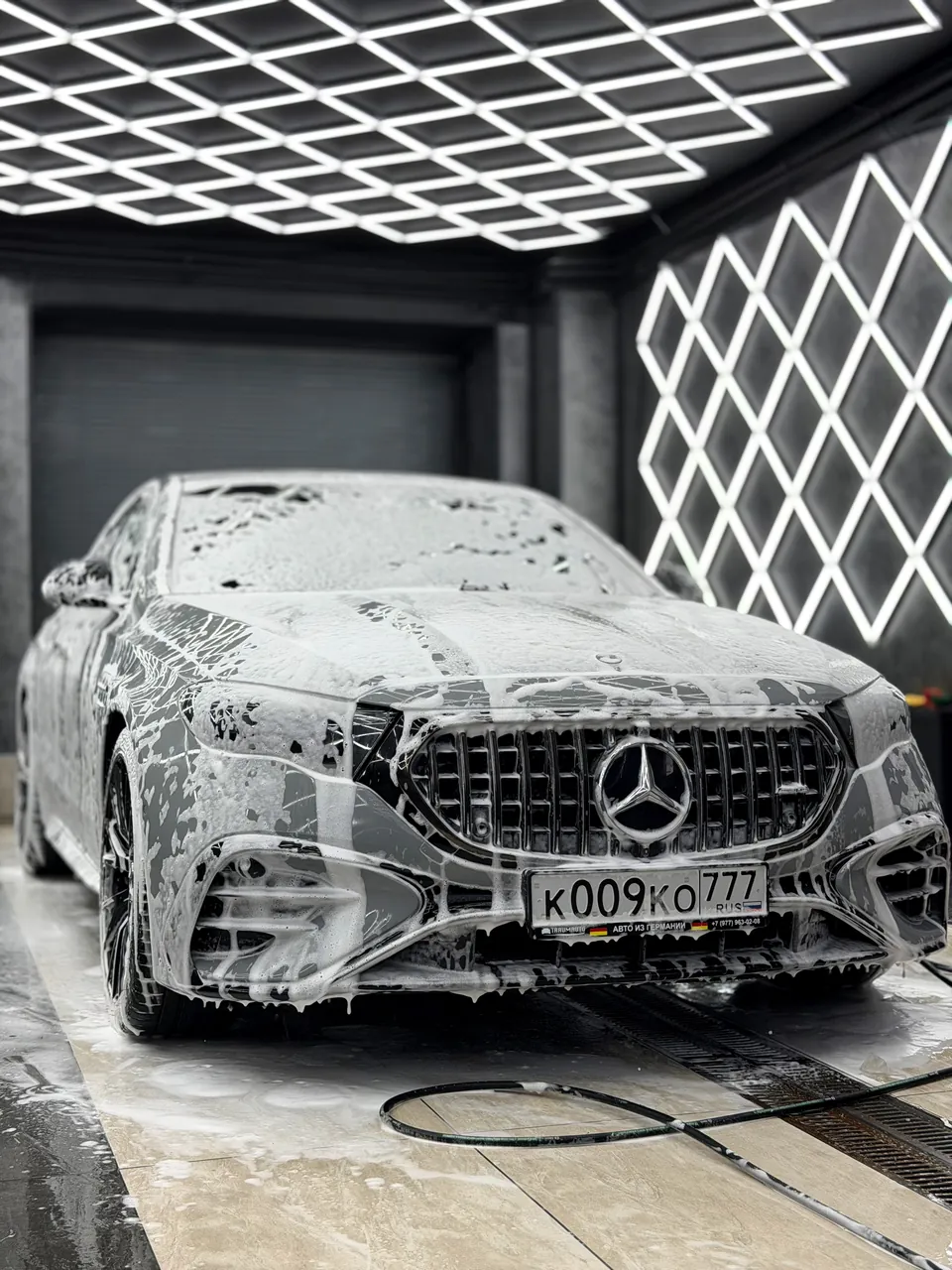 Серый Mercedes-Benz в активной пене во время детейлинг-мойки в студии МГК